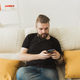 Handsome hipster man using cellphone at home. Communication leisure and technologies concept - PhotoDune Item for Sale