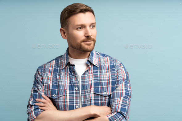 Contented satisfied guy smiles, looks away isolated background. Confident man crossed arms in studio - Stock Photo - Images