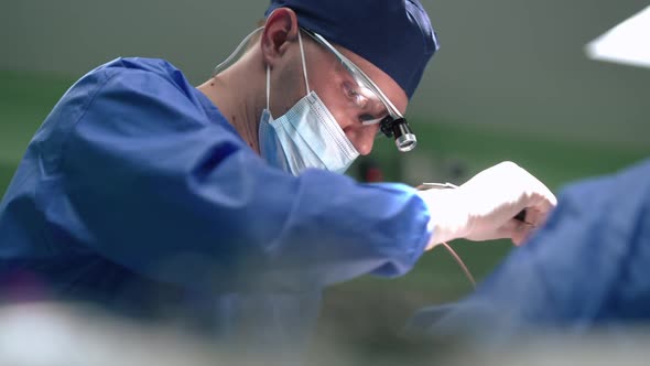Confident Plastic Surgeon Stitching Dissection with Cautery Machine in Slow Motion alt
