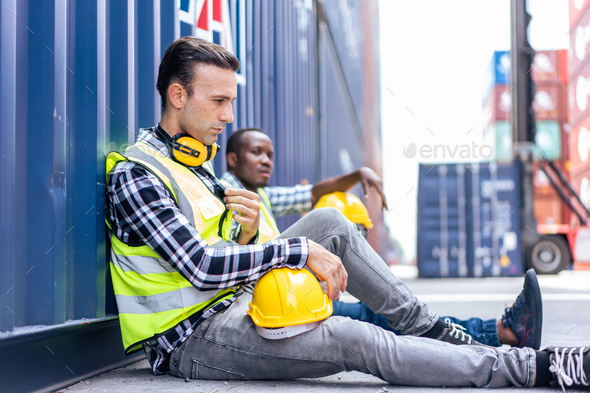 Caucasian man worker taking a break after working in container port.