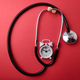 Top view stethoscope and alarm clock on a red background - PhotoDune Item for Sale