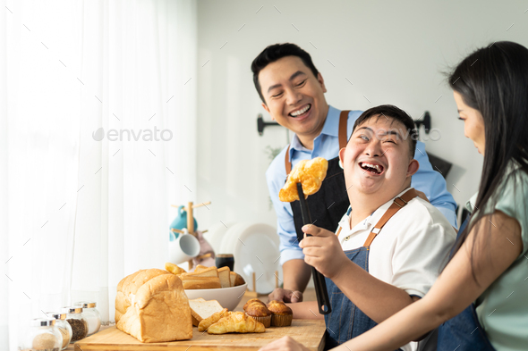 Asian happy family baking bakery with down syndrome's son in kitchen. Stock  Photo by s_kawee