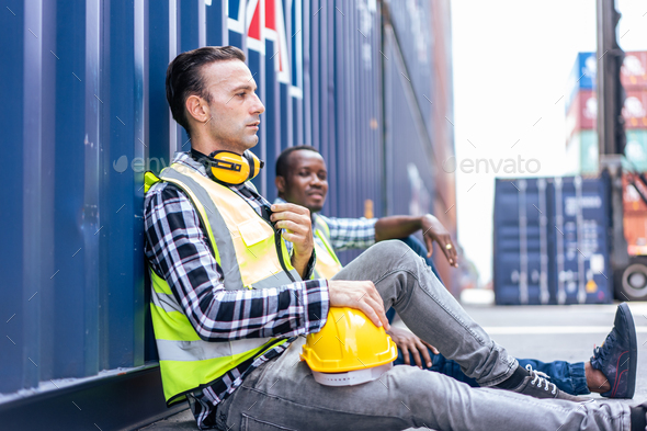 Caucasian man worker take a break after work in container port terminal.