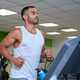 Strong Latin man running on treadmill at a gym. - PhotoDune Item for Sale