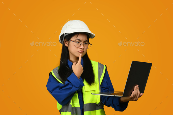 Asian girl holding helmet isolated on yellow background, future dream job career.