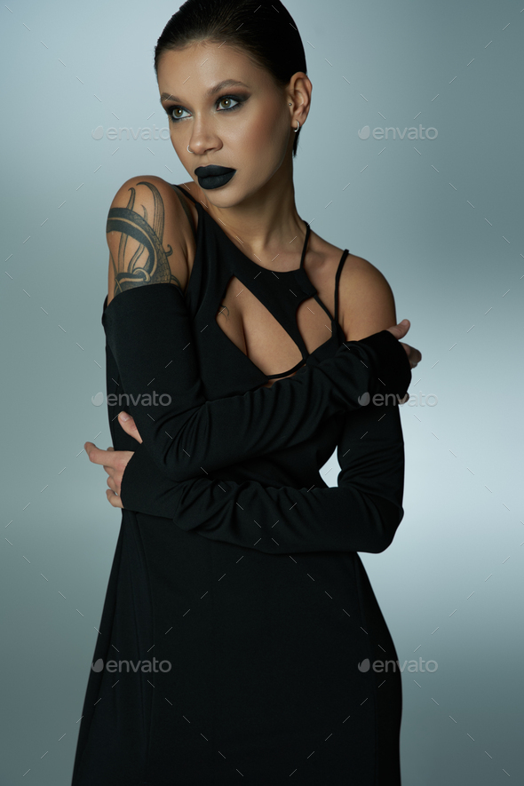 mesmerizing asian woman with brunette hair and bold makeup,wearing black  cocktail dress and gloves Stock Photo by LightFieldStudios