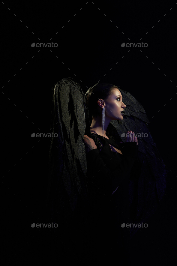 woman in costume of fallen angel with black wings praying with closed eyes  on white, banner Stock Photo by LightFieldStudios
