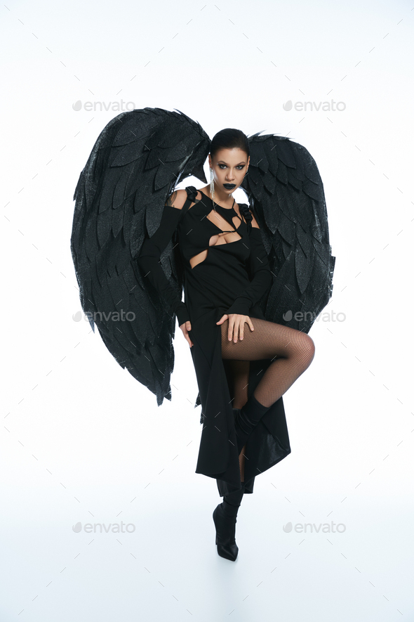 woman in costume of fallen angel with black wings praying with closed eyes  on white, banner Stock Photo by LightFieldStudios