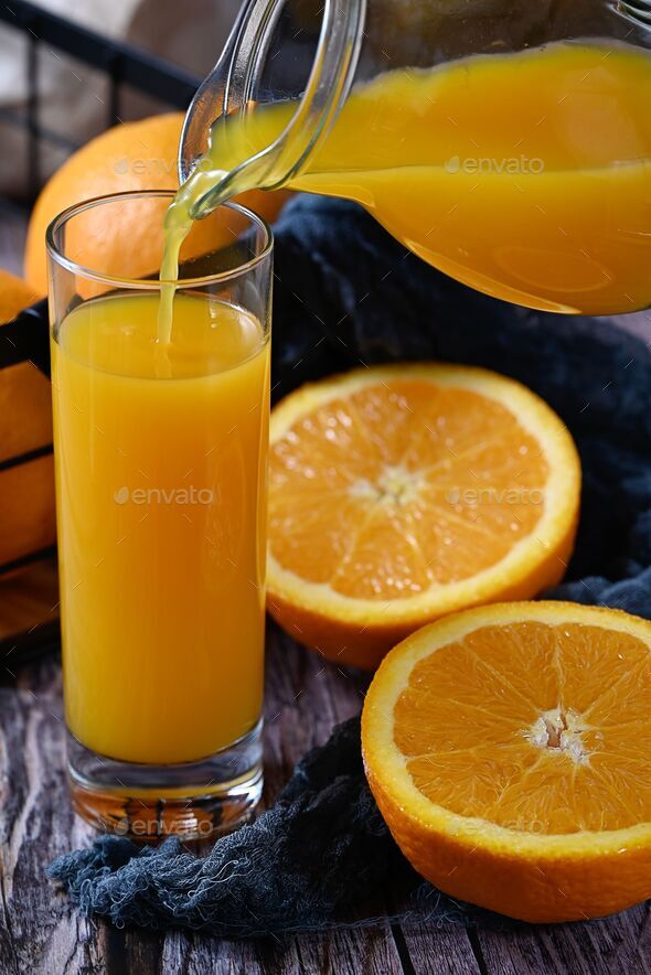 Glass and pitcher with orange juice on transparent