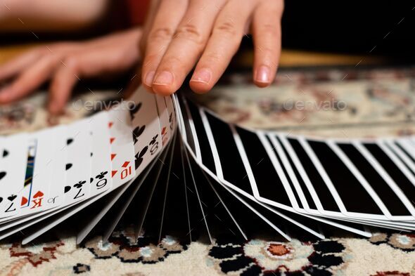 Closeup of person's hands shuffling the card deck on the table