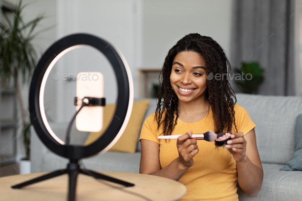 Beauty blog. Black lady blogger advertising new cosmetics products, making makeup filming on