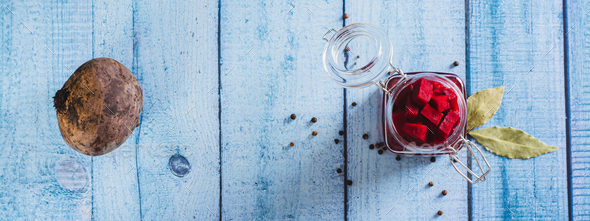 Delicious pickled beets with allspice and bay leaf in a jar on the table top view web banner