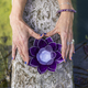 Top angle view of hands holding a purple glass lotus on a tree trunk over water.  - PhotoDune Item for Sale