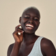 Happy young African Black woman beauty model at beige background. Portrait. - PhotoDune Item for Sale