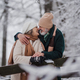 Elegant senior couple kissing in the snowy park, during cold winter snowy day. - PhotoDune Item for Sale
