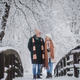 Elegant senior couple walking in the snowy park, during cold winter snowy day. - PhotoDune Item for Sale