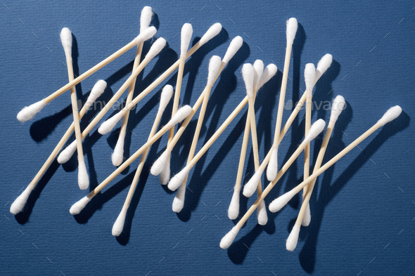 Bunch of disposable cotton buds, using for artificial eyelash extension procedure on blue background