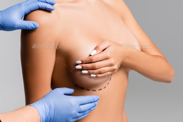 Young nude woman with covered breast touching face. Skin pampering concept.  Stock Photo