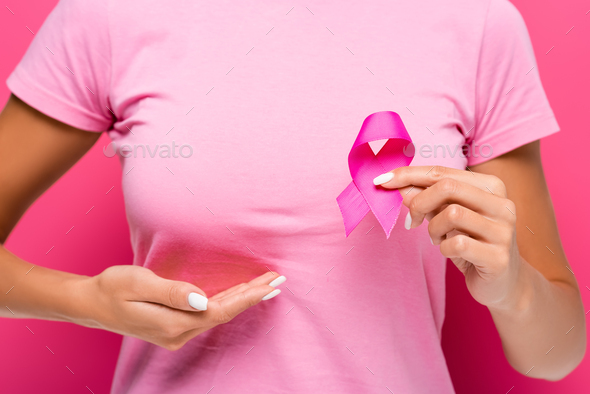 Colored illustration of a woman pointing at a breast cancer ribbon