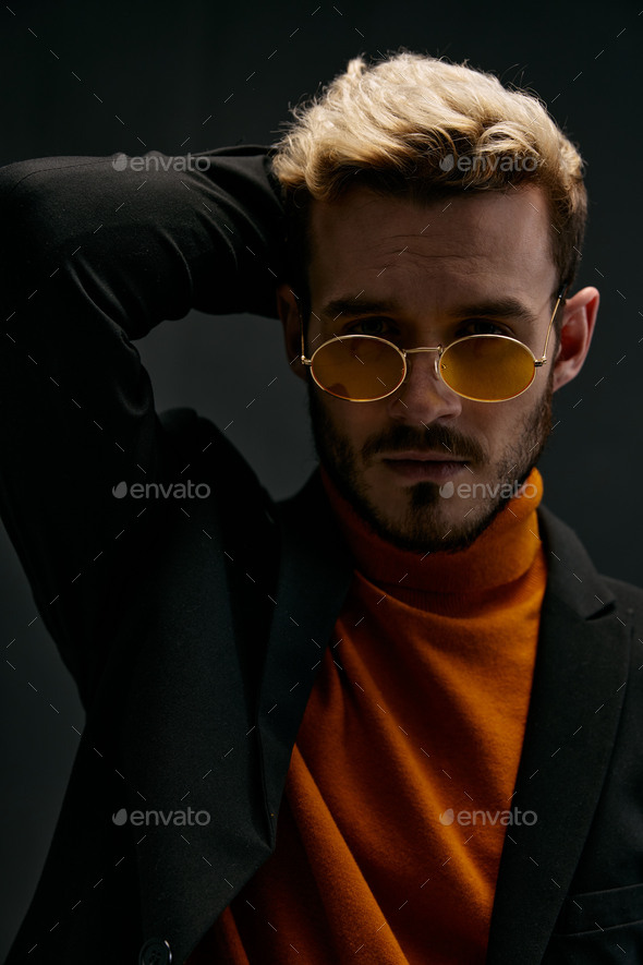 a fashionable man with glasses and an orange sweater jacket trend of the fall season