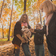 Mother and grandmother and daughter holds jack russell terrier and plays with it in autumn outside - PhotoDune Item for Sale