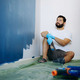 home renovation. caucasian bearded man having rest after painting wall - PhotoDune Item for Sale