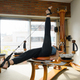 adult woman lying with one leg up and one down on pulley and weight machine at home - PhotoDune Item for Sale