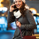 Portrait of smiling woman using mobile phone in the city at winter. People communication concept - PhotoDune Item for Sale