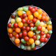 on black background, from above a round plate of colourful tomatoes - PhotoDune Item for Sale