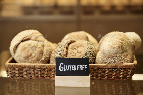 Fresh breads in basket in artisan bakery with Gluten free sign
