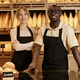 Two young workers in artisan bakery standing behind counter and smiling - PhotoDune Item for Sale