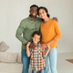Diverse Parents Embracing Son Smiling To Camera Posing At Home - PhotoDune Item for Sale