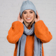 Young woman in knitted wear and hat smiling at camera on white background - PhotoDune Item for Sale