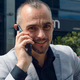 Close-up of attractive French Caucasian man talking on phone smiling and looking at camera. - PhotoDune Item for Sale