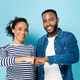 joyful african american couple doing fist bump while looking at camera on blue - PhotoDune Item for Sale