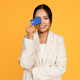 Happy young asian woman in suit has fun, put credit card to eye, isolated on yellow studio - PhotoDune Item for Sale