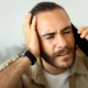 Closeup of millennial man in pain calling doctor on phone - PhotoDune Item for Sale