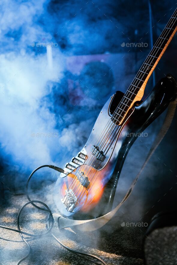 Vertical shot of a bass guitar on the stage with a fog machine