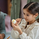 Cute little girl carefully painting Easter egg in preschool - PhotoDune Item for Sale