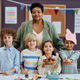 Female teacher posing with diverse group of children in preschool - PhotoDune Item for Sale