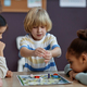 Diverse group of little kids playing board game together in preschool - PhotoDune Item for Sale