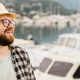 Banner millennial man wearing hat and glasses near marina with yachts. Portrait of laughing man with - PhotoDune Item for Sale