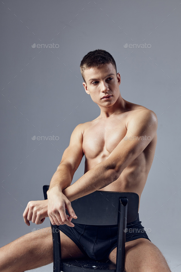 bodybuilder posing isolated on grey background. Handsome power athletic guy  male looking at his bicep muscle. Fitness muscular body Stock Photo | Adobe  Stock