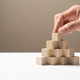 Hand putting wood cubes arrange in a pyramid shape mock-up - PhotoDune Item for Sale