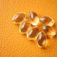 Close up of many vitamin capsule on orange background  - PhotoDune Item for Sale
