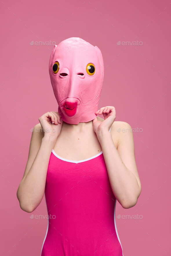 Very strange woman in a pink silicone fish mask for Halloween, crazy image in pink clothes
