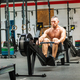 Strong man exercising on rowing machine in gym - PhotoDune Item for Sale