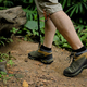 Hiker man with trekking sticks walking along the forest path. Traveling and adventure concept - PhotoDune Item for Sale