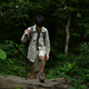Young man with backpack trekking in forest, enjoying his recreation time in nature. - PhotoDune Item for Sale