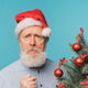 Angry sad Santa scares kids, man wears santa hat show aggressive emotions - negative and bad mood - PhotoDune Item for Sale
